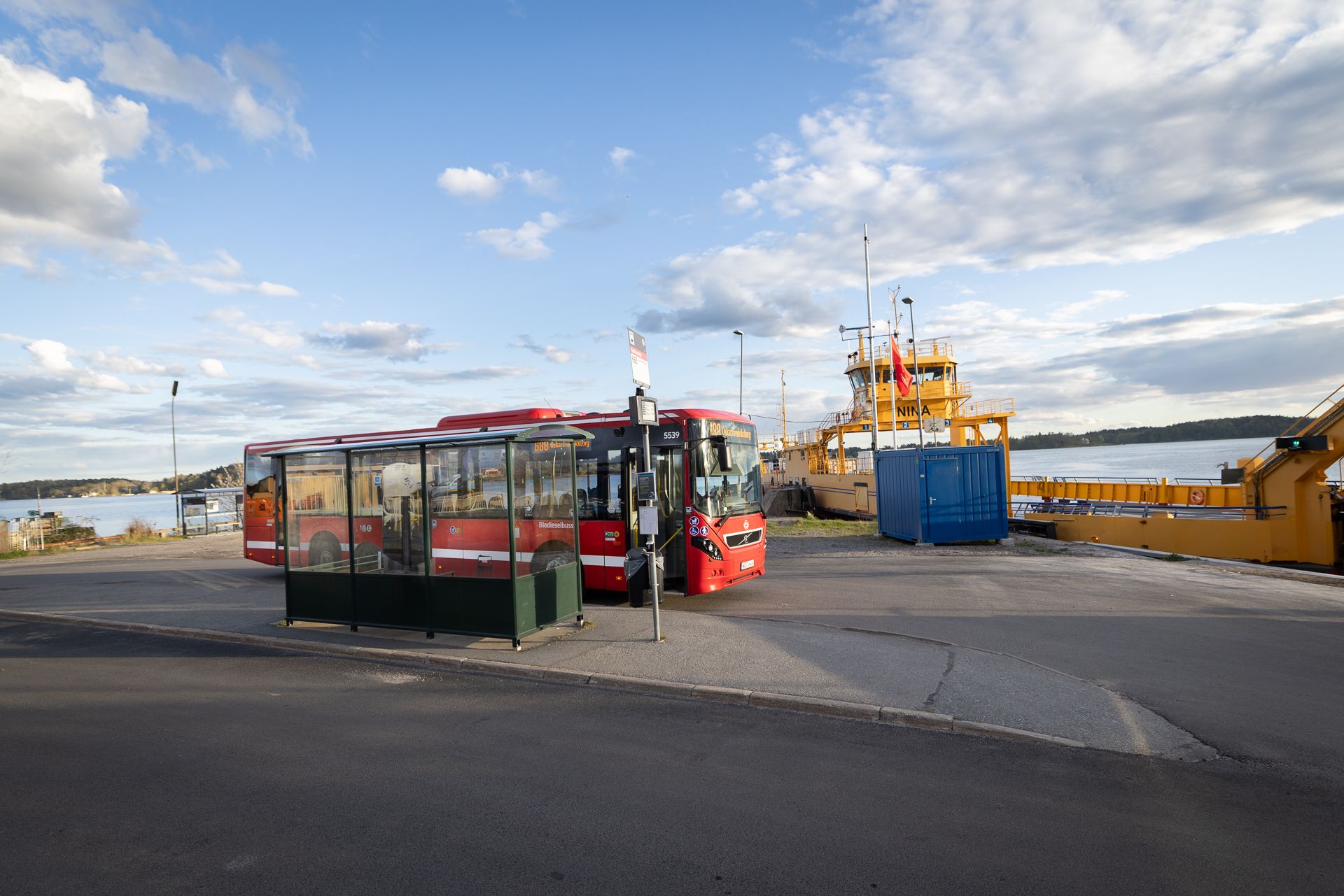 Buss 688 vid hållplatsen Rindö smedja med färjan Nina i bakgrunden